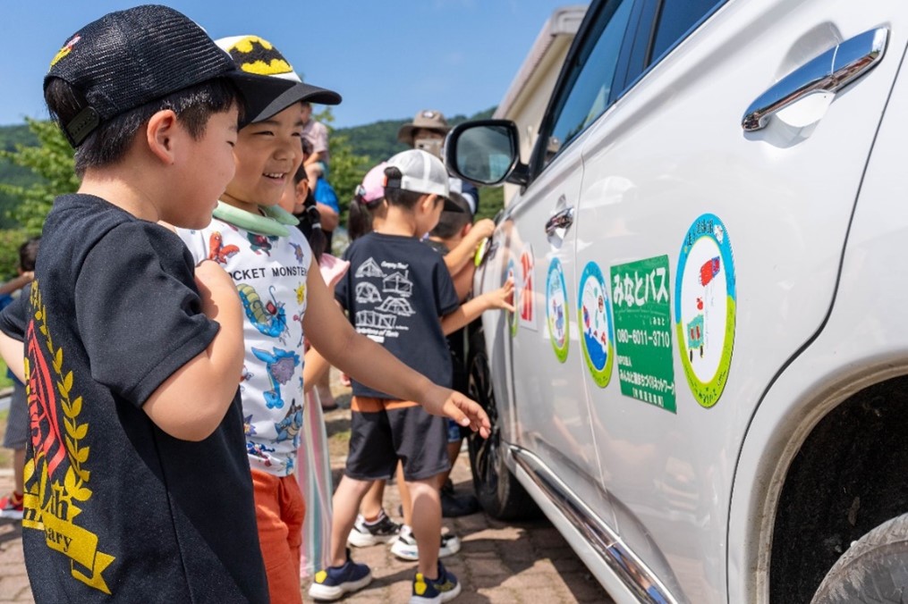 みなとバス車体にステッカーを貼り付ける様子